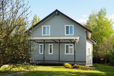 Cottagecore contemporary two-story house of timber in countryside in spring . Russian dacha in Moscow region. Backyard and traditional relax gardening.の写真素材