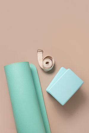 Green yoga blocks and white strap on beige background. Yoga practice, relaxation and meditation concept. Top view with copy space. Vertical format.の写真素材