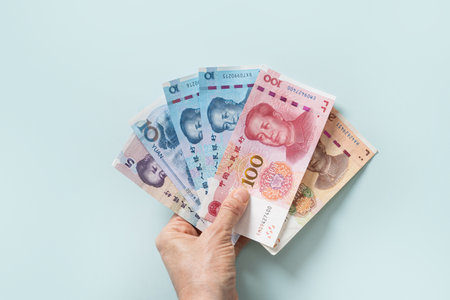 Many of different Chinese yuan banknotes in female hand. Chinese paper currency Yuan renminbi...