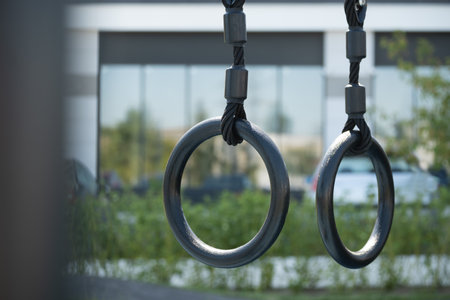 Gymnastic rings to strengthen the arms on street sport ground. Outdoor sports field. Healthy lifestyle. Close up.の写真素材