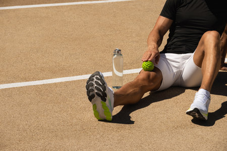 Athletes man is massaging his leg by massage ball techniques for tense after active workout on...