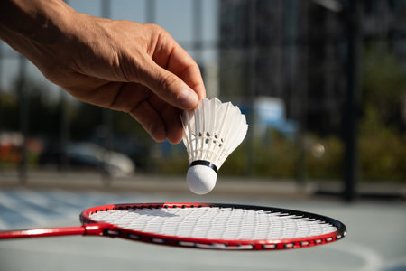 White badminton shuttlecock and badminton rackets on floor sport badminton court in sunny shadow. Outdoors. Close up.の写真素材