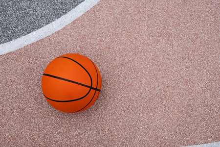 Basketball orange ball on colorful sport field with white line. Sports gear without people. Sport background. Team sport. Copy space. View from aboveの写真素材