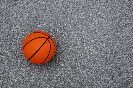Basketball orange ball on gray sport field. Sports gear without people. Sport background. Team sport. Copy space. View from aboveの写真素材