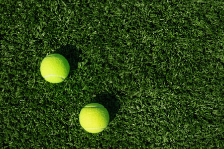 Two yellow tennis balls on green sports ground and artificial grass covering. View from above. Summer sports.の写真素材