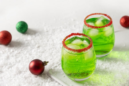 Xmas Green Punch in glass decorated sugar rim on white table make of cool lime sherbet. Tasty drink for Christmas holiday. Rim your festive beverages in red sugar.の写真素材