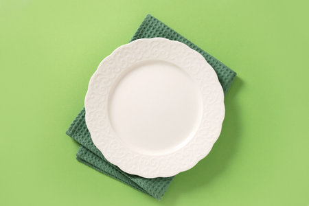 White plate on green background. View from above. Banner.の写真素材