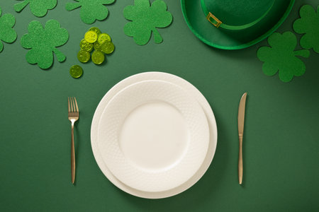St Patrick's Day festive table setting with white plate, leprechaun hat and clover leaves on green...