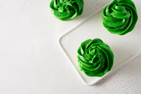 St. Patricks Day tasty cupcakes with green whipped cream on white background. Close up. View from above. Copy space.の写真素材