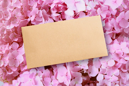 Blank card, envelope on pink hydrangea flowers background. Greeting card with space for greetings...
