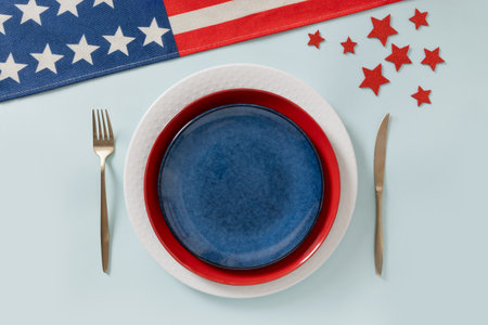 Patriotic table setting for USA Independence Day. Festive dinner with empty white plate and...