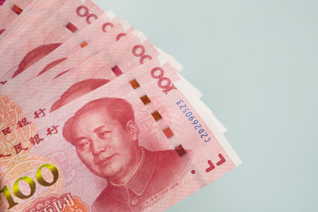 Large stack of Chinese yuan banknotes on blue background. Copy space. Close up.の写真素材