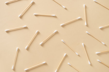 Wooden ecological cotton swab on beige background. Zero waste, sustainable resources. View from above.の写真素材