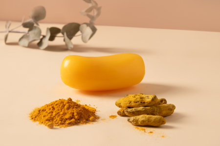 Handmade turmeric soap bars, powder and turmeric root on yellow background. Organic skincare product perfect for wellness, beauty, and organic body care concepts. Close up.の写真素材