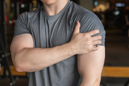 Athlete or young man standing with pain in shoulder at gym. Arm, inflammation or exercise with...
