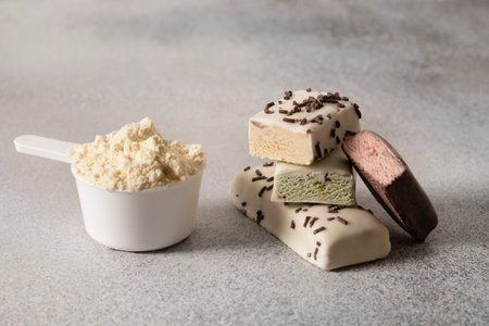 Protein bars and scoop of powder on gray background. Close up.の写真素材