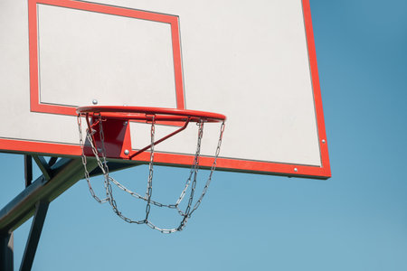Basketball backboard hoop on sports court against clear blue sky. Outdoors. Summer game. Copy space....