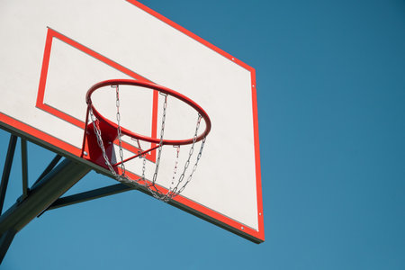 Basketball backboard hoop on sports court against clear blue sky. Outdoors. Summer game. Copy space....