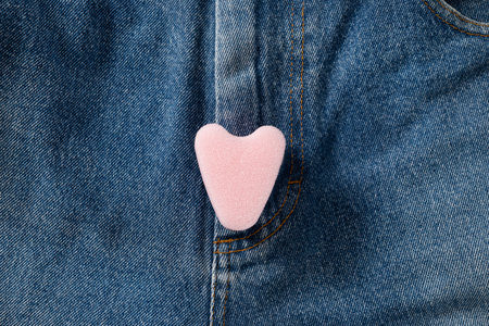 Pink foam tampon stringless as heart on jeans. New generation. Hygiene accessories for women. View from above.の写真素材