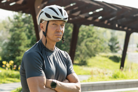 Portrait of cyclist in white helmet with cross hand at city public park. Summer leisure activities. Outdoors.の写真素材