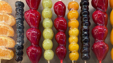Chinese dessert Tanghulu made from crunchy caramelized fruit on a skewer. Sweet street food. Many colorful tanghulu, traditional snack.の写真素材
