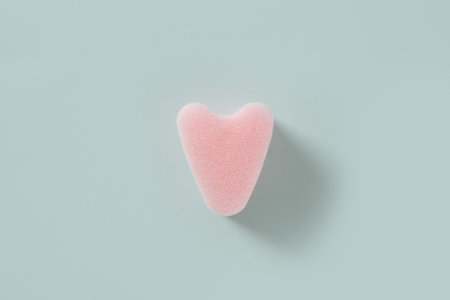 Female pink tampon stringless as heart in individual package on blue background. Hygiene accessories...