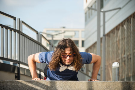 Athlete does push ups and workout in stairs. Outdoors training. Morning routine. Workout. Healthy lifestyle and disciplineの写真素材