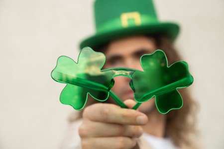 Man holding shamrock glasses celebrating St Patrick day