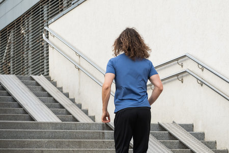 Sporty man and athlete wearing blue t-shirt running at stair