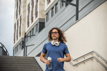 Sporty man and athlete wearing blue t-shirt running at stairの写真素材