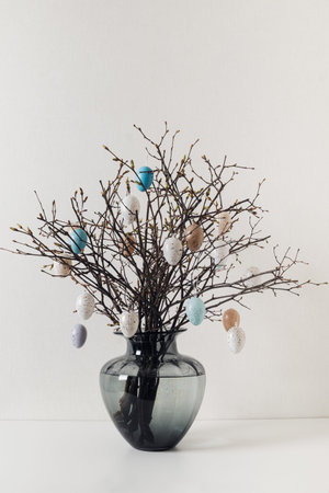 Easter branches with decorative eggs in glass vase