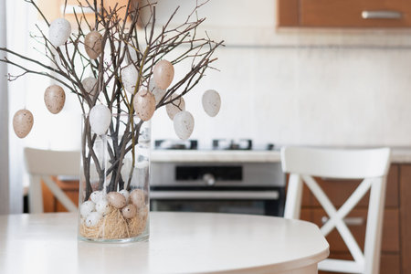 Easter table decor with branches and eggs in modern kitchen