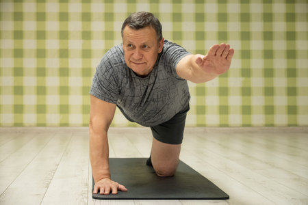 Senior Man doing balancing yoga posture on mat. Balance and Flexibility Training