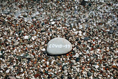 Stones on the sea and the inscription covid-19