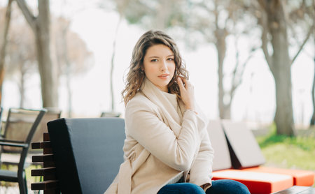 Beautiful young brunette girl sitting in a parkの写真素材