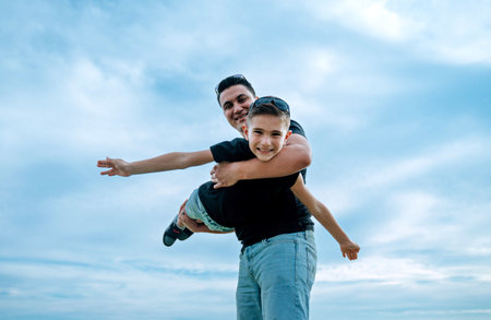 Father and son playing and having fun. Concept of happy family and of summer vacationの写真素材
