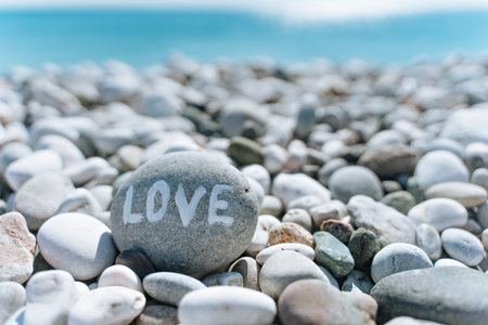 stones on the beach with a blue sea and the inscription loveの写真素材