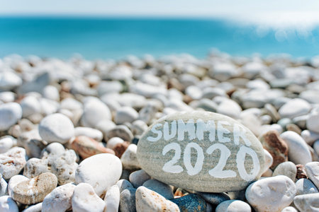stones on the beach with a blue sea and the inscription summerの写真素材