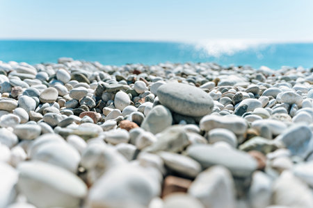 stones on the beach with a blue sea and blue sky on backgroundの写真素材