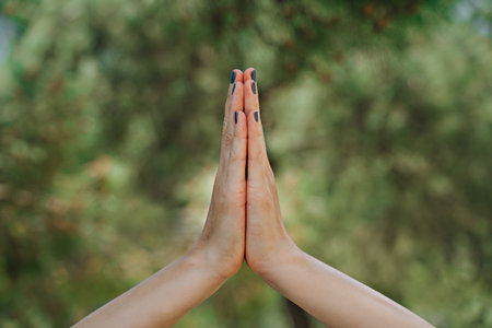 Female hands in yoga pose and green backgroundの写真素材