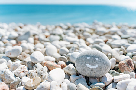 stones on the beach with a blue sea and the inscription smileの写真素材