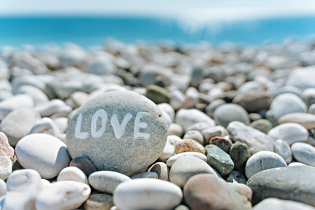 stones on the beach with a blue sea and the inscription loveの写真素材
