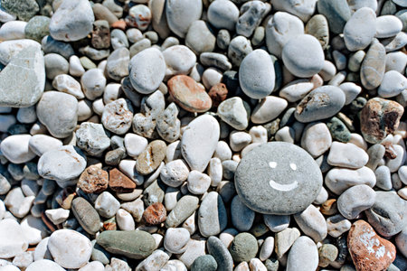 stones on the beach with a blue sea and the inscription smileの写真素材