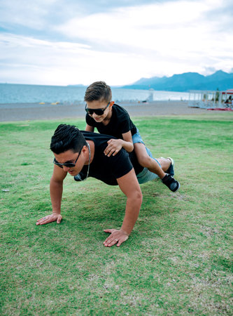 Father and son playing and having fun doing sport together. Concept of happy family and of summer vacationの写真素材