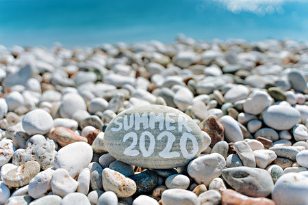 stones on the beach with a blue sea and the inscription summerの写真素材