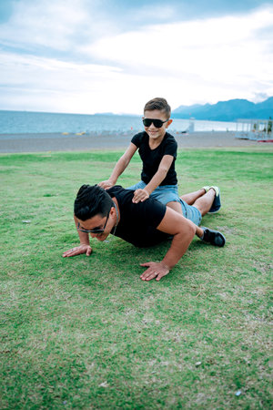 Father and son playing and having fun doing sport together. Concept of happy family and of summer vacationの写真素材