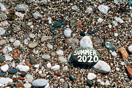 stones on the beach with a blue sea and the inscription summerの写真素材