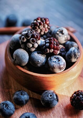 fresh blueberries and blackberries in a wooden bowlの写真素材