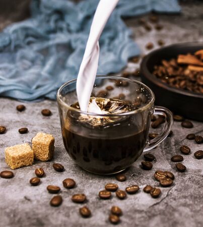 Cream is poured into a Cup of coffeeの写真素材