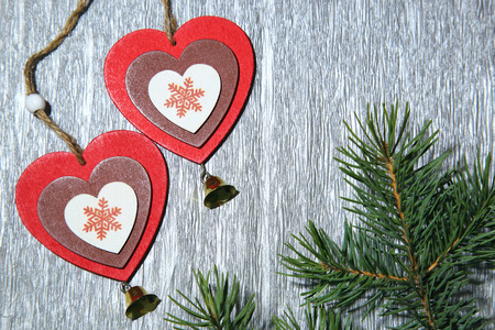 Christmas, New Year, St. Valentine's Day, love. Two multicolored hearts with snowflakes and a branch of spruce on a gray silvery shiny background.の写真素材